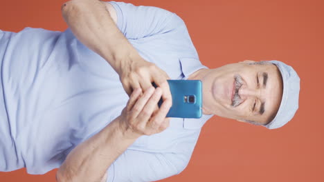 Vertical-video-of-The-old-man-who-happily-puts-the-phone-to-his-heart.